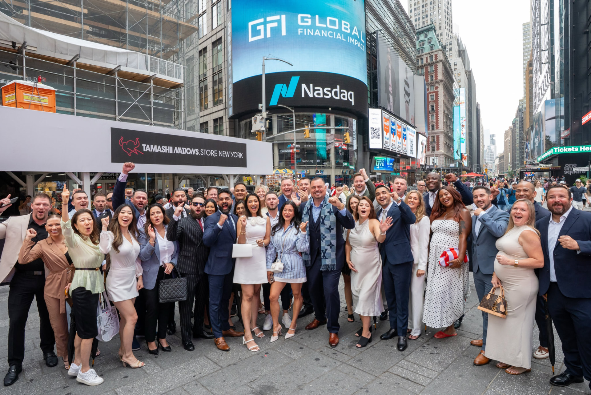 The GFI team celebrating together in Times Square beneath the Global Financial Impact and Nasdaq screens